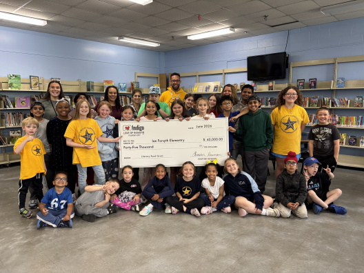 Student and staff took a photo with a large cheque from Indigo