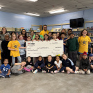 Student and staff took a photo with a large cheque from Indigo